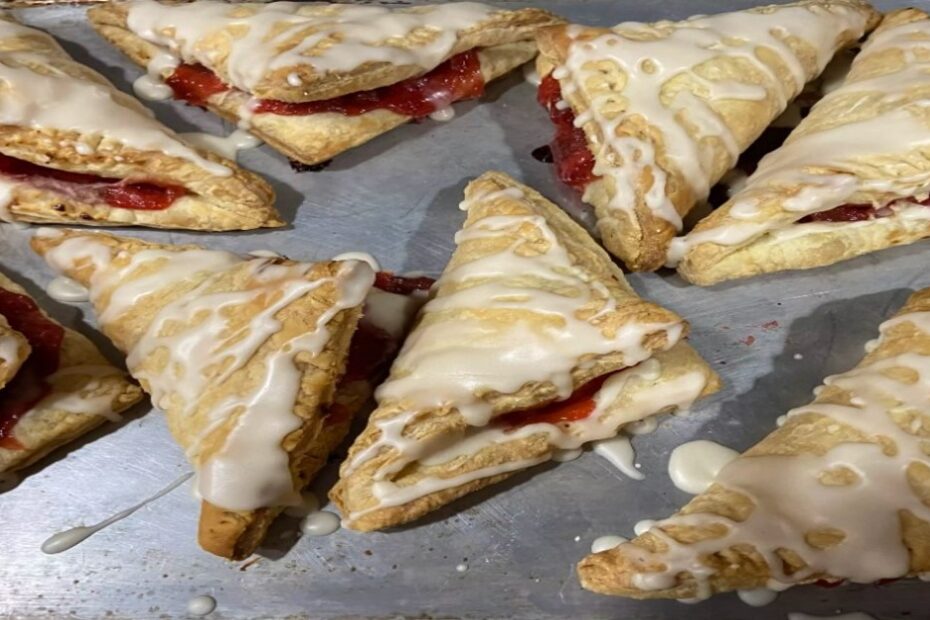 Ein goldbrauner Apfel-Crisp mit knuspriger Haferflocken-Kruste, serviert in einer weißen Auflaufform, umgeben von frischen Äpfeln und einer Zimtstange.